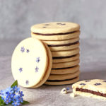 vegane Doppelkekse mit Schokolade und essbaren Blüten